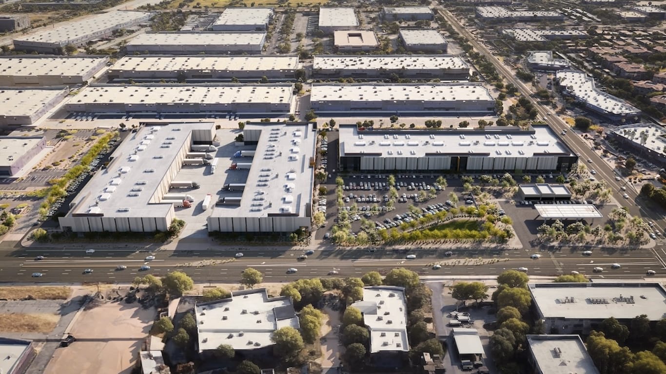 Aerial architectural rendering of Nexus Commerce Center showing multiple warehouse-style buildings with loading docks, parking lots, and surrounding road infrastructure in a desert urban setting