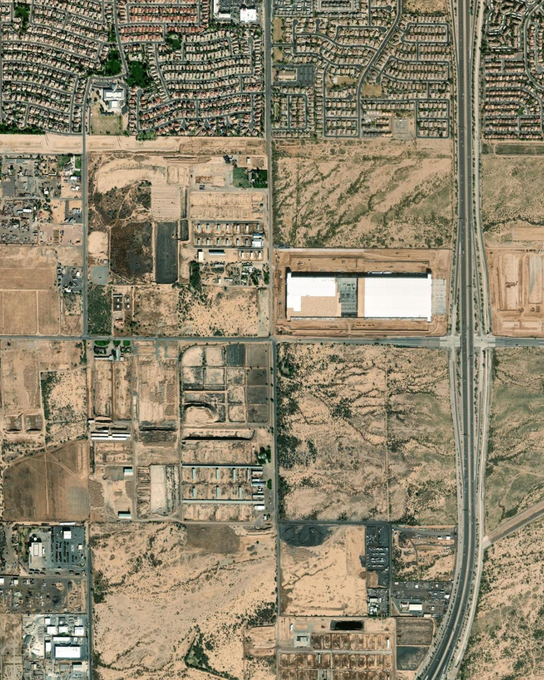 Satellite aerial vicinity map of Hawes Crossing showing all eight villages outlined in orange dashed boundaries, with Village 7 highlighted in green dashed lines at the southeast corner of Hawes Road and Elliot Road in Mesa