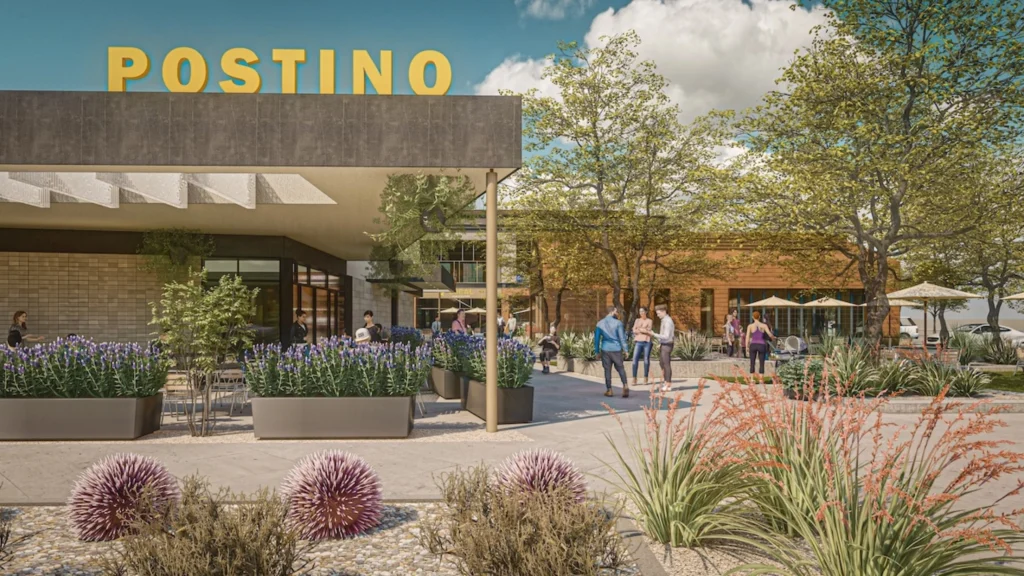 Architectural rendering of a Postino restaurant exterior with a large yellow POSTINO rooftop sign, desert landscaping with purple flowers and agave, an outdoor patio, and pedestrians in a shared plaza.