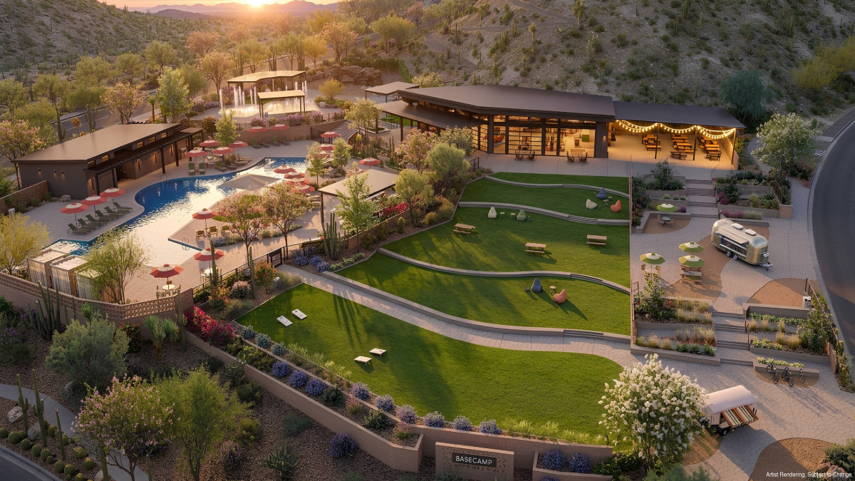 Aerial architectural rendering of Basecamp at Saddleback showing a freeform pool with red umbrellas and lounge chairs, a large clubhouse pavilion with string lights, tiered green lawns with picnic tables, a vintage Airstream food trailer, desert landscaping with cacti, and a hillside backdrop at golden hour
